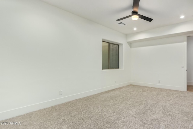 spare room with ceiling fan and light colored carpet