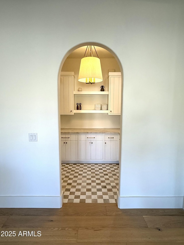 kitchen with hanging light fixtures, white cabinets, and dark wood-type flooring