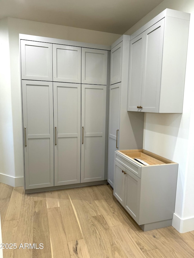 kitchen with gray cabinetry and light hardwood / wood-style flooring