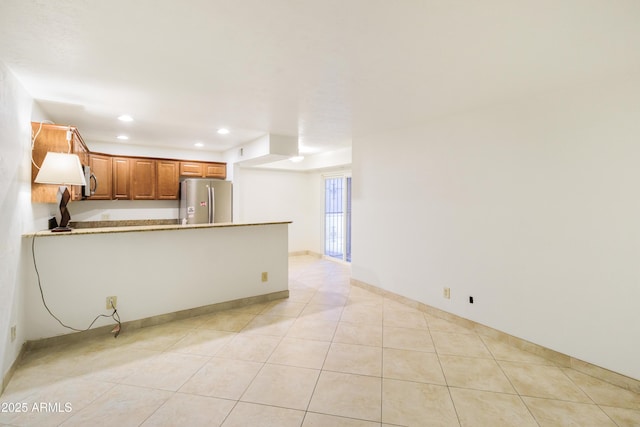 kitchen featuring appliances with stainless steel finishes, kitchen peninsula, and light tile patterned floors