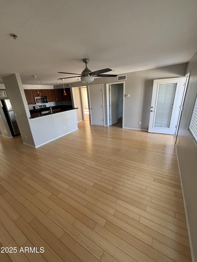 unfurnished living room featuring visible vents, baseboards, light wood-style floors, and ceiling fan
