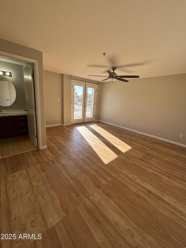 unfurnished bedroom featuring baseboards, access to outside, and wood finished floors