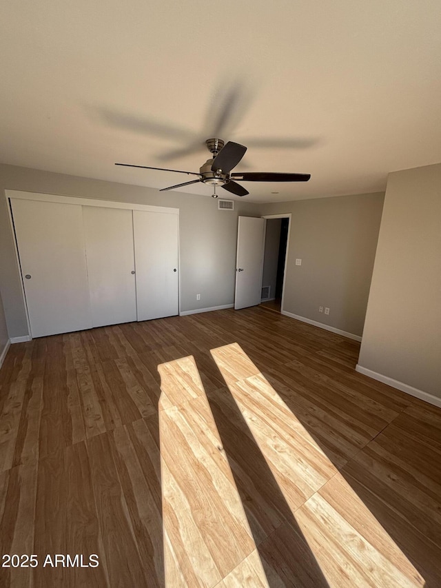 unfurnished bedroom with baseboards, visible vents, and wood finished floors
