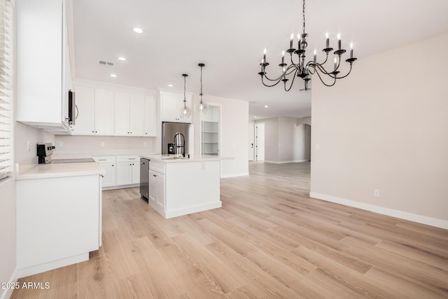 kitchen featuring white cabinetry, hanging light fixtures, a center island with sink, stainless steel appliances, and light hardwood / wood-style floors