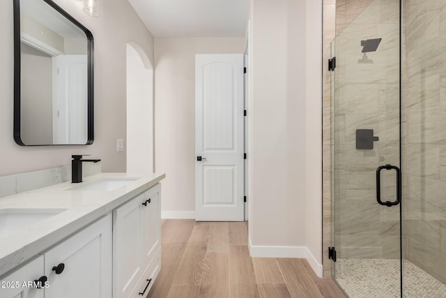 bathroom featuring hardwood / wood-style flooring, vanity, and a shower with door