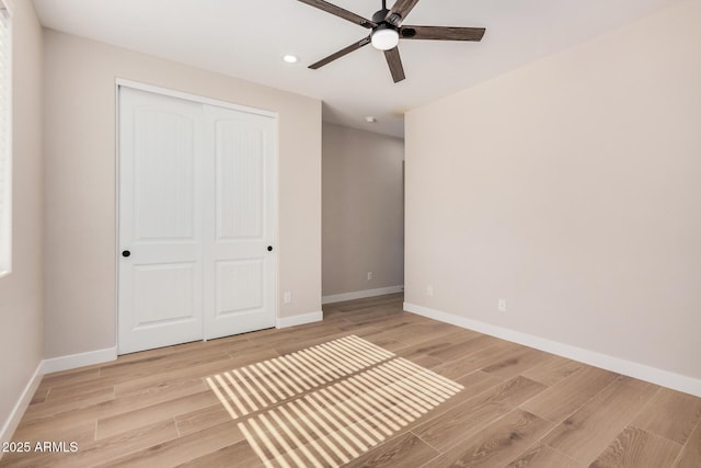 unfurnished bedroom featuring light hardwood / wood-style floors, a closet, and ceiling fan