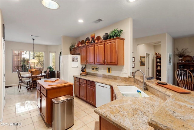 kitchen with a sink, light countertops, dishwasher, and decorative light fixtures