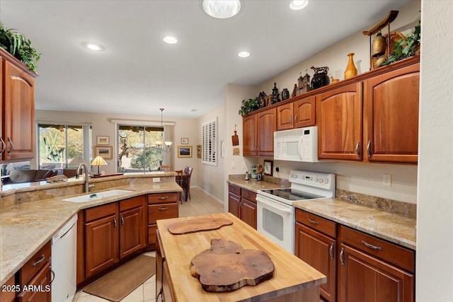 kitchen featuring sink, white appliances, light tile patterned flooring, hanging light fixtures, and wood counters