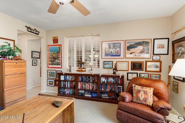 sitting room featuring ceiling fan and baseboards