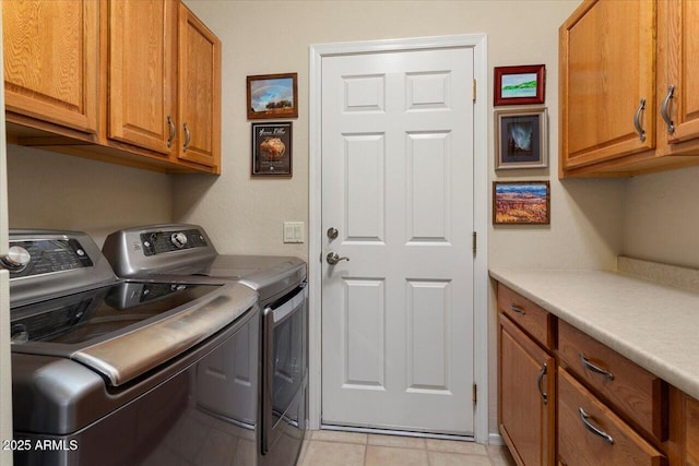 laundry area featuring cabinets, independent washer and dryer, and light tile patterned flooring