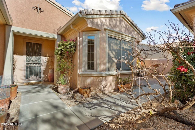 view of side of home featuring a patio area and stucco siding