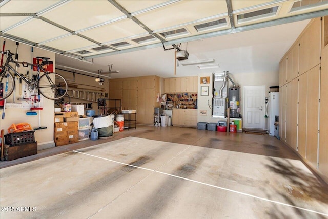 garage with water heater, a garage door opener, and gas water heater