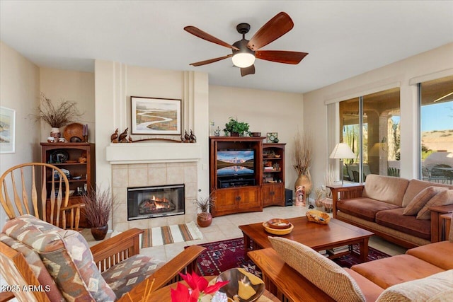 tiled living room featuring ceiling fan and a tiled fireplace