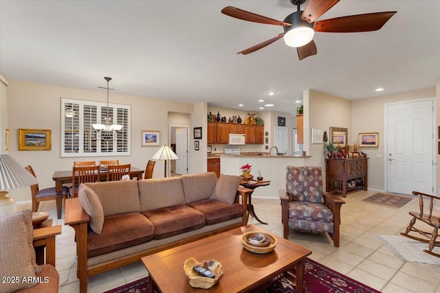 living room featuring ceiling fan with notable chandelier, recessed lighting, baseboards, and light tile patterned floors