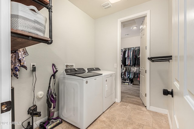 laundry room with washer and clothes dryer and light tile patterned floors