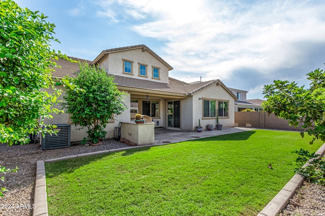 rear view of house featuring central AC, a lawn, and a patio area