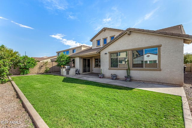 rear view of house with a lawn and a patio