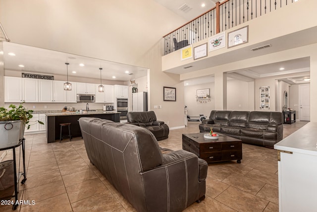 tiled living room with a high ceiling and sink