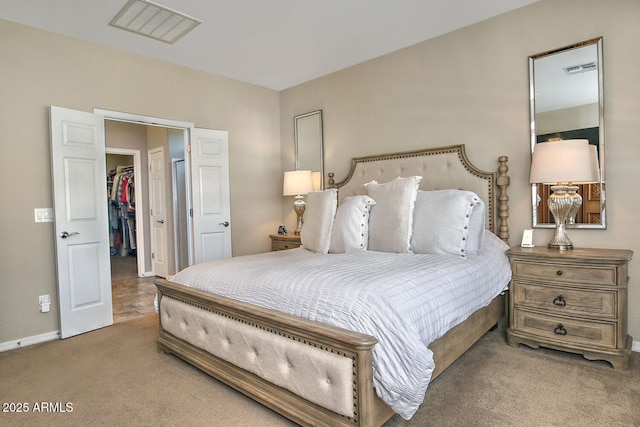 carpeted bedroom with a spacious closet and a closet