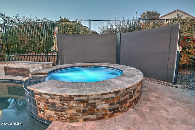 view of swimming pool featuring an in ground hot tub, pool water feature, and a patio area