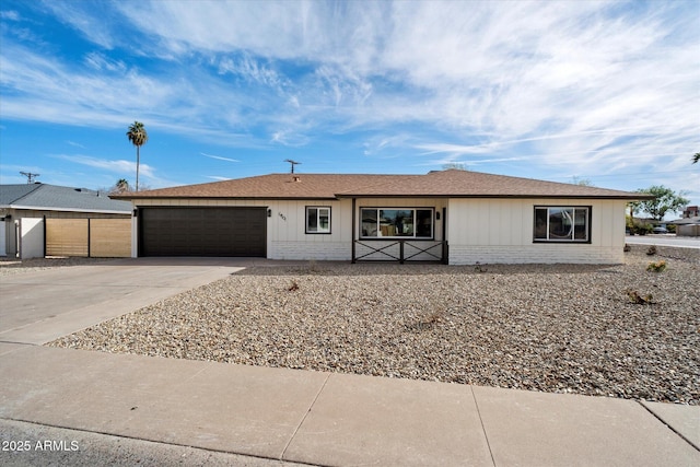 single story home with driveway, an attached garage, roof with shingles, and brick siding