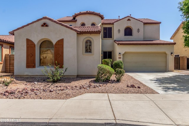 mediterranean / spanish house with driveway, a garage, a tiled roof, and stucco siding