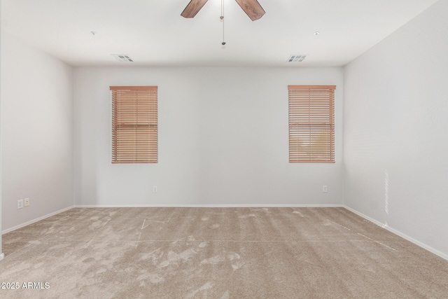 spare room with visible vents, ceiling fan, and carpet