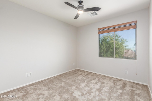 carpeted spare room featuring a ceiling fan, baseboards, and visible vents