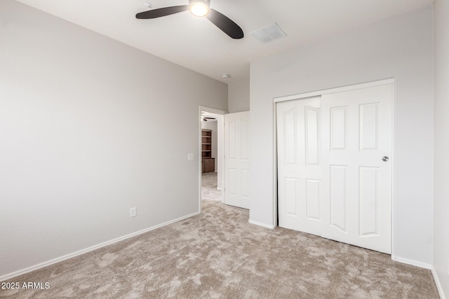 unfurnished bedroom with a closet, visible vents, baseboards, a ceiling fan, and carpet floors