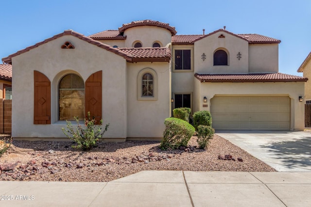mediterranean / spanish-style house featuring a tiled roof, stucco siding, and driveway