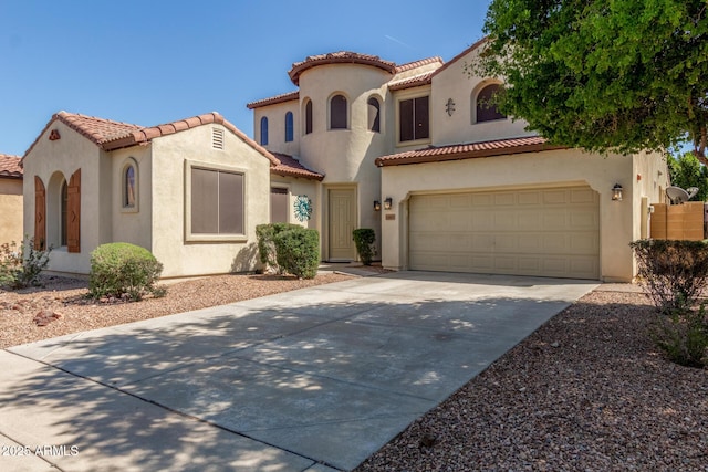 mediterranean / spanish home featuring a tile roof, concrete driveway, stucco siding, and an attached garage