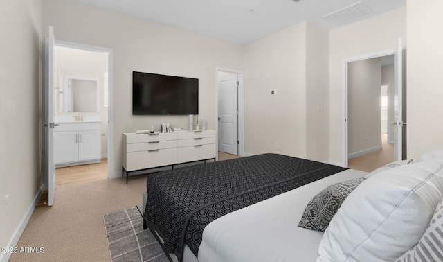 bedroom featuring connected bathroom and light colored carpet