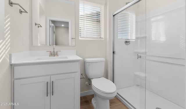 bathroom featuring vanity, toilet, a shower with shower door, and wood-type flooring