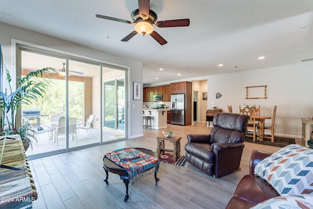 living room featuring light wood-type flooring and ceiling fan