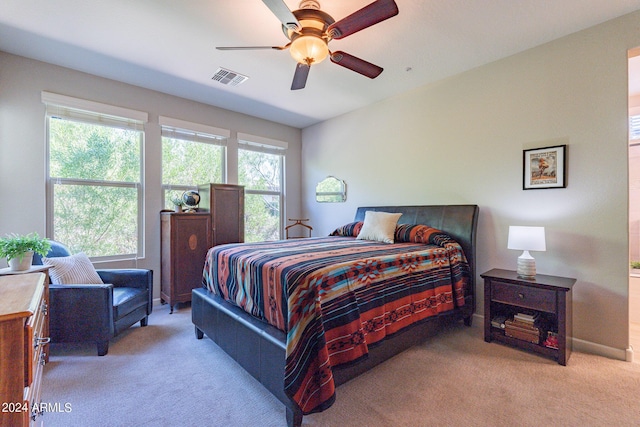 bedroom featuring light carpet, visible vents, and a ceiling fan