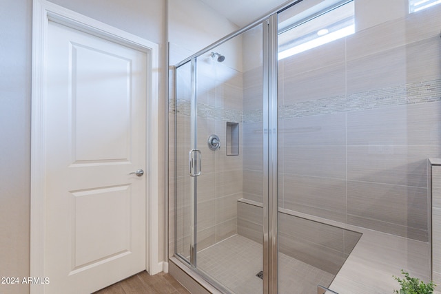 bathroom with hardwood / wood-style floors and walk in shower