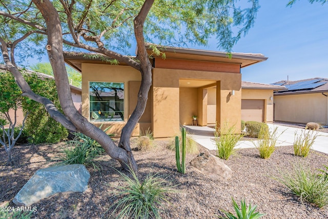 view of front of house featuring driveway, stucco siding, and an attached garage