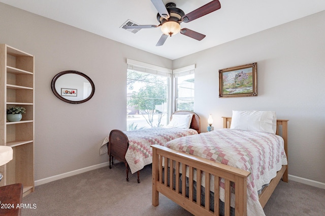 bedroom with a ceiling fan, light carpet, and baseboards