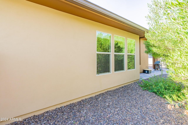 view of side of property with stucco siding and a patio area