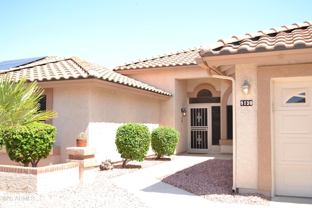 9130 W Utopia Rd, Peoria, AZ 85382 - view of exterior entry with stucco siding, a garage, and a tile roof