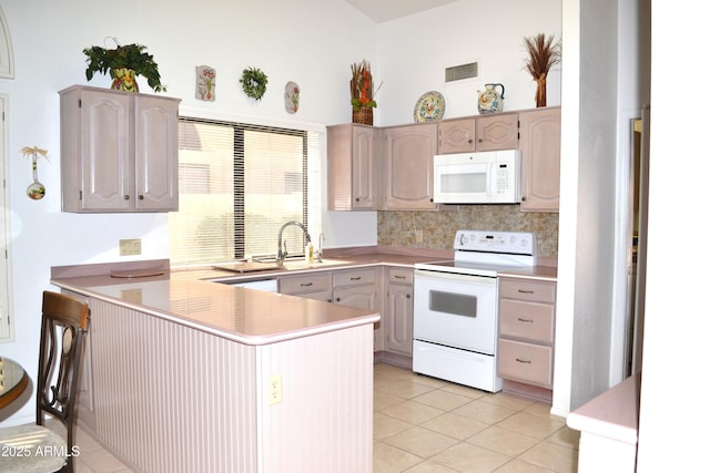 9130 W Utopia Rd, Peoria, AZ 85382 - kitchen with white appliances, a peninsula, light tile patterned flooring, light countertops, and tasteful backsplash