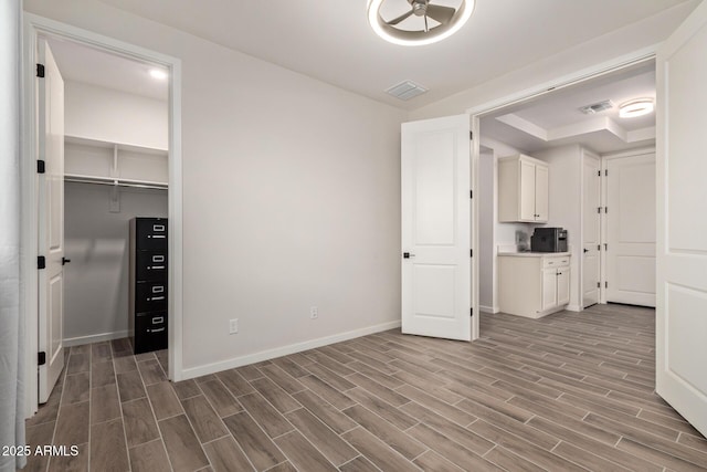 interior space featuring baseboards, visible vents, and wood finish floors