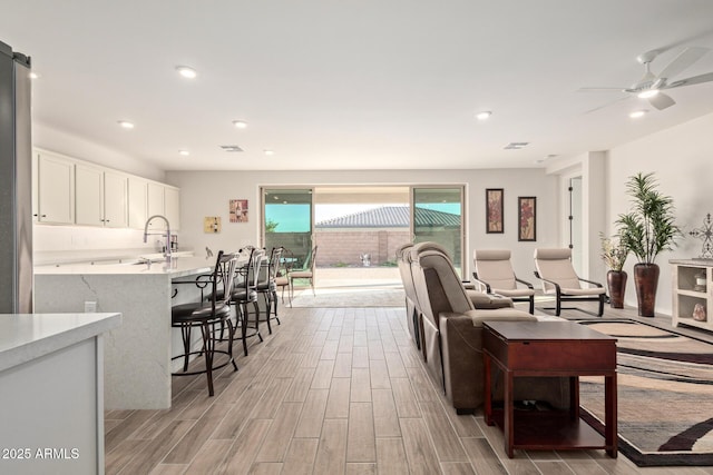 living area with recessed lighting, visible vents, ceiling fan, and wood finish floors