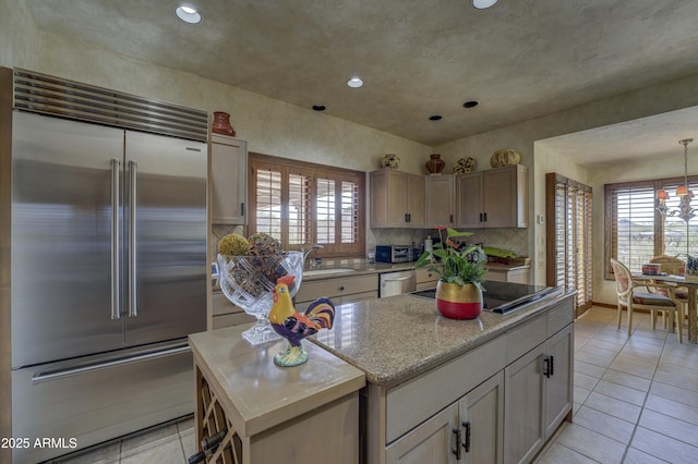 kitchen featuring a sink, light tile patterned flooring, appliances with stainless steel finishes, and a center island