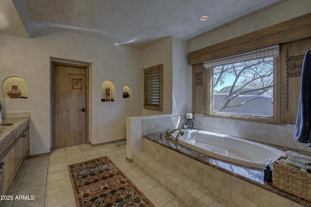 bathroom with tile patterned floors, a bath, and baseboards