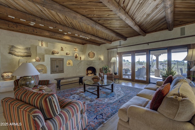 living room featuring beamed ceiling, wood finished floors, french doors, a fireplace, and wood ceiling