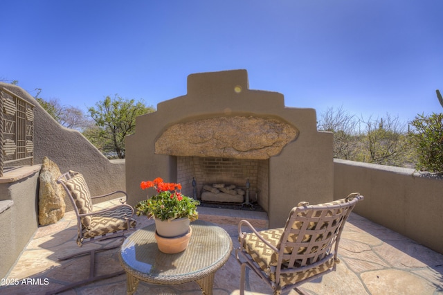 view of patio with an outdoor fireplace