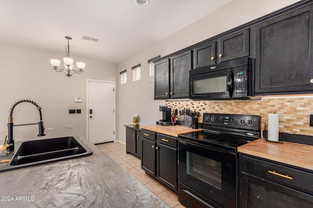 kitchen featuring sink, light tile patterned floors, backsplash, hanging light fixtures, and black appliances