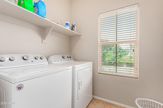 washroom with washing machine and clothes dryer and light tile patterned floors