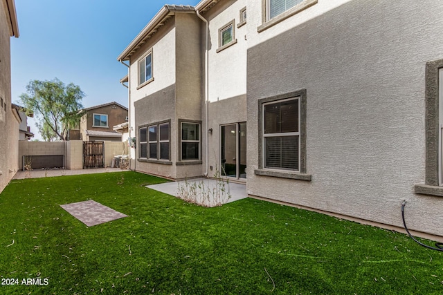 rear view of house featuring a yard and a patio